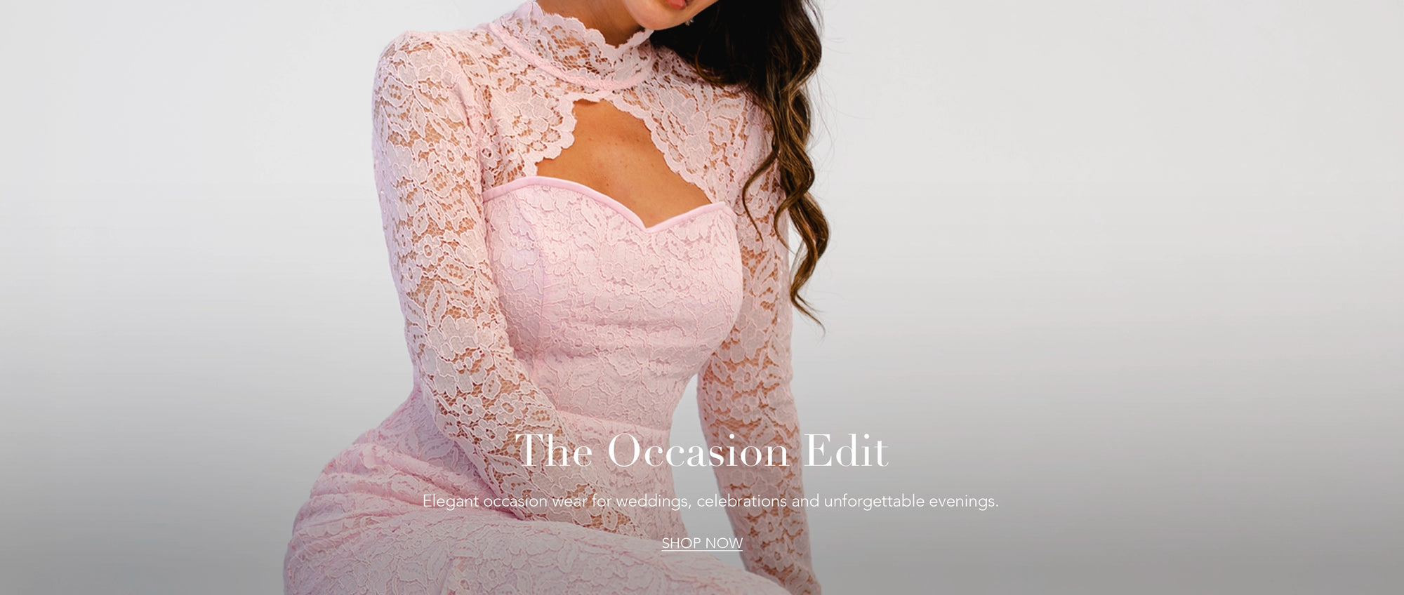 Woman wearing a pink lace dress with a blurred background